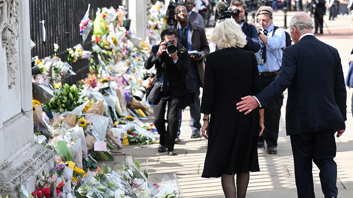 King Charles III and Camilla look at floral tributes