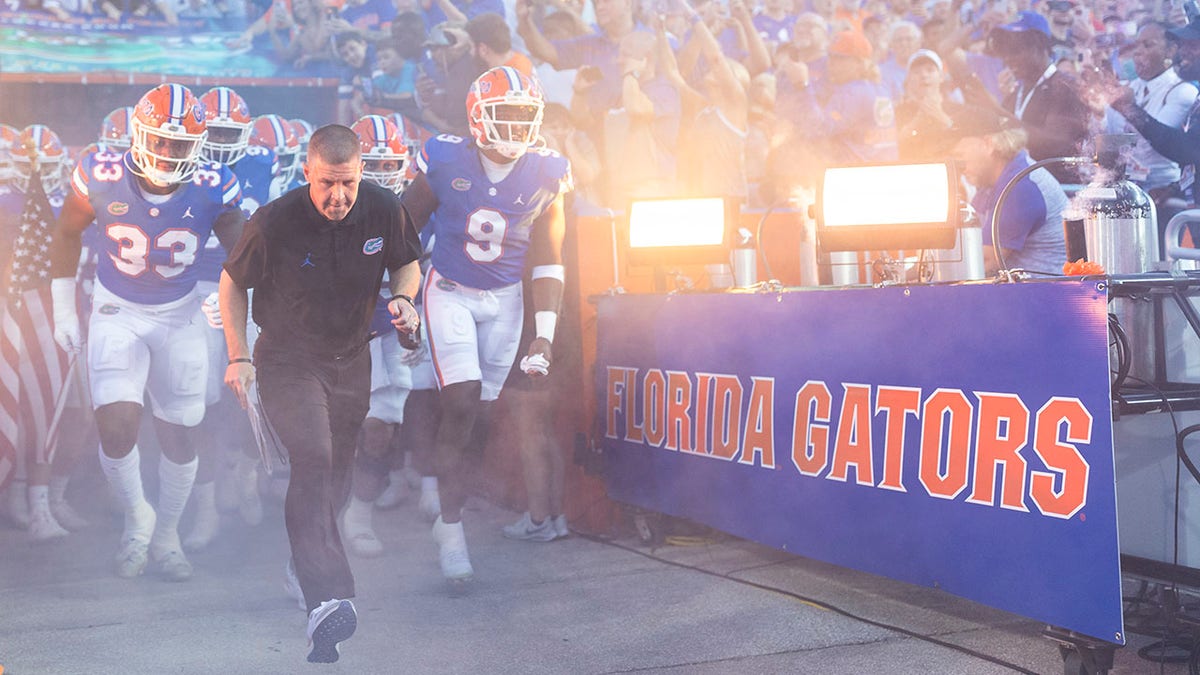 Florida Gators head coach Billy Napier runs out onto the field