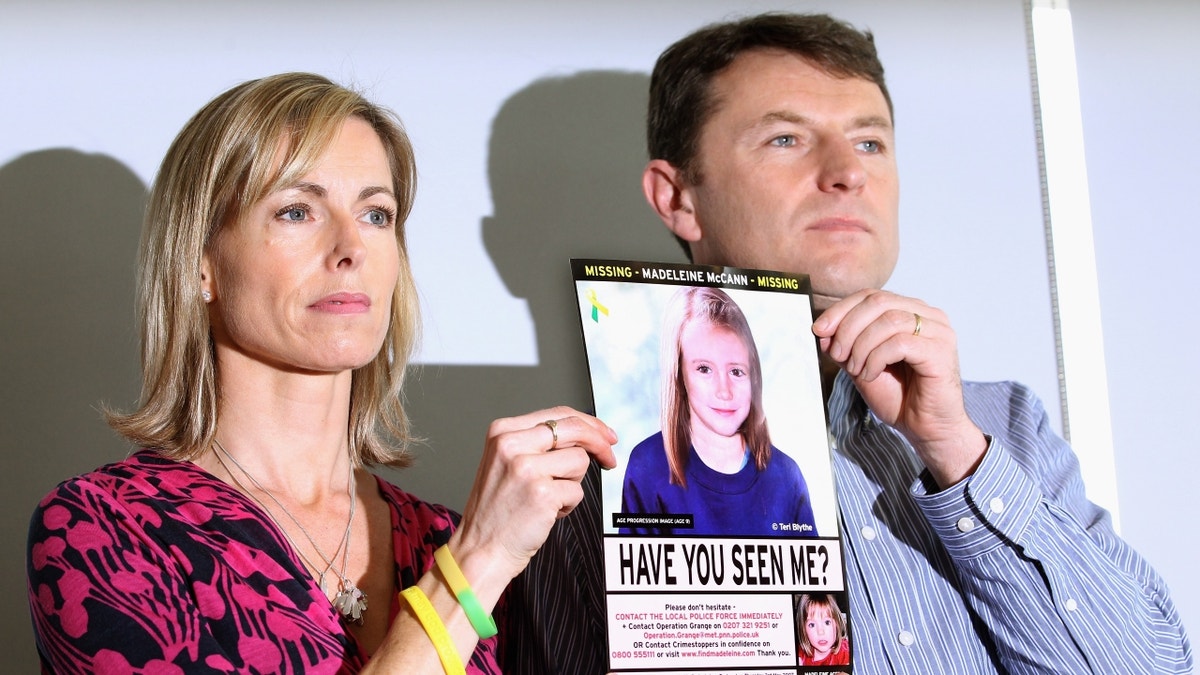 Kate and Gerry McCann holding picture of Madeleine McCann