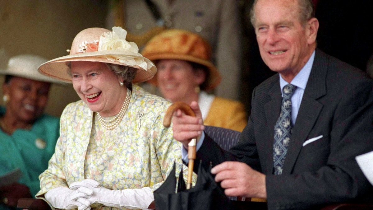 Queen Elizabeth sitting down, laughing