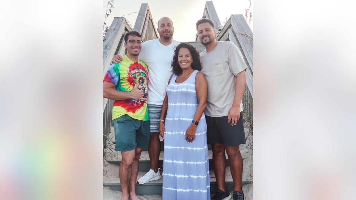 Marcela Leahy standing with her three sons posing for a photo