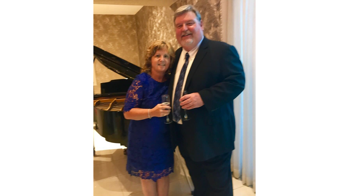 Mike Hanson pictured with wife Cathy Hanson in front of a piano