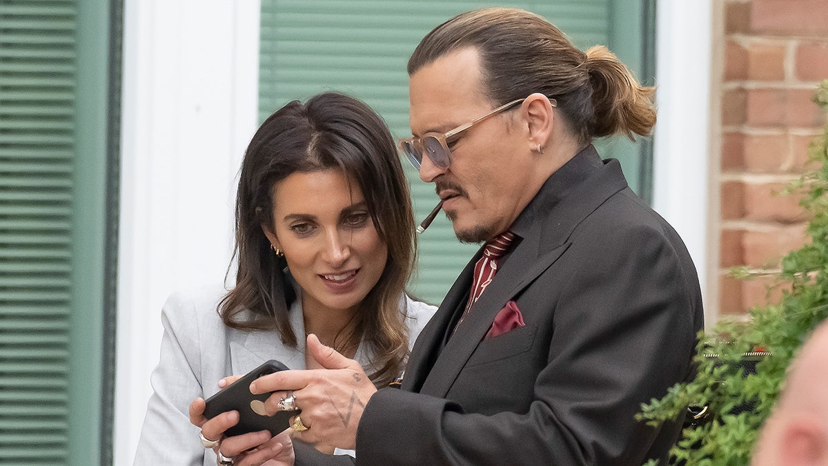 Johnny Depp smoking a cigarette as he chats with girlfriend Joelle Rich