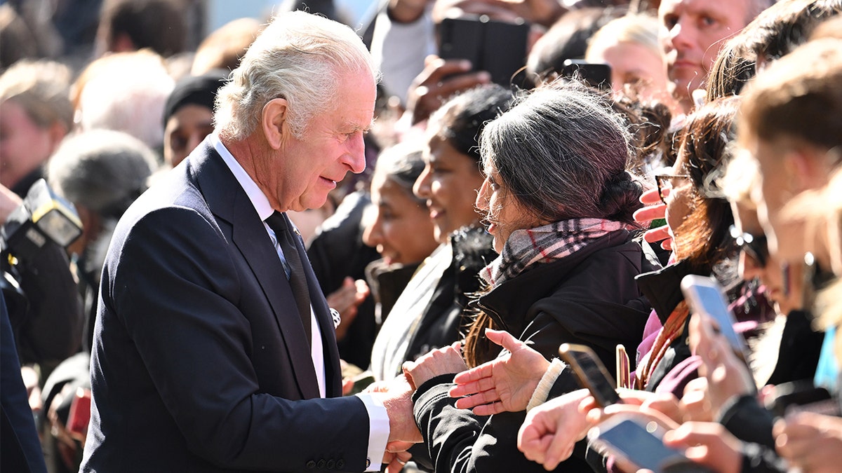 King Charles III shakes hands with mourners waiting to pay respects to Queen Elizabeth lying in state
