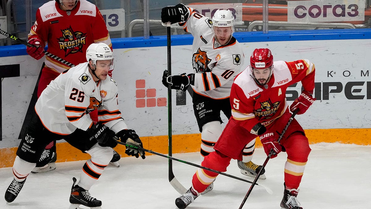 FILE - Kunlun Red Star's Ryan Sproul, right, of Canada, fights for the puck with Amur's Radan Lenc, left, during the Kontinental Hockey League ice hockey match between Kunlun Red Star Beijing and Amur Khabarovsk in Mytishchi, just outside Moscow, Russia, on Nov. 15, 2021. North Americans playing in the Russia-based KHL have been put in a difficult position amid calls from the U.S and Canadian governments for them to leave the country because of the war in Ukraine.