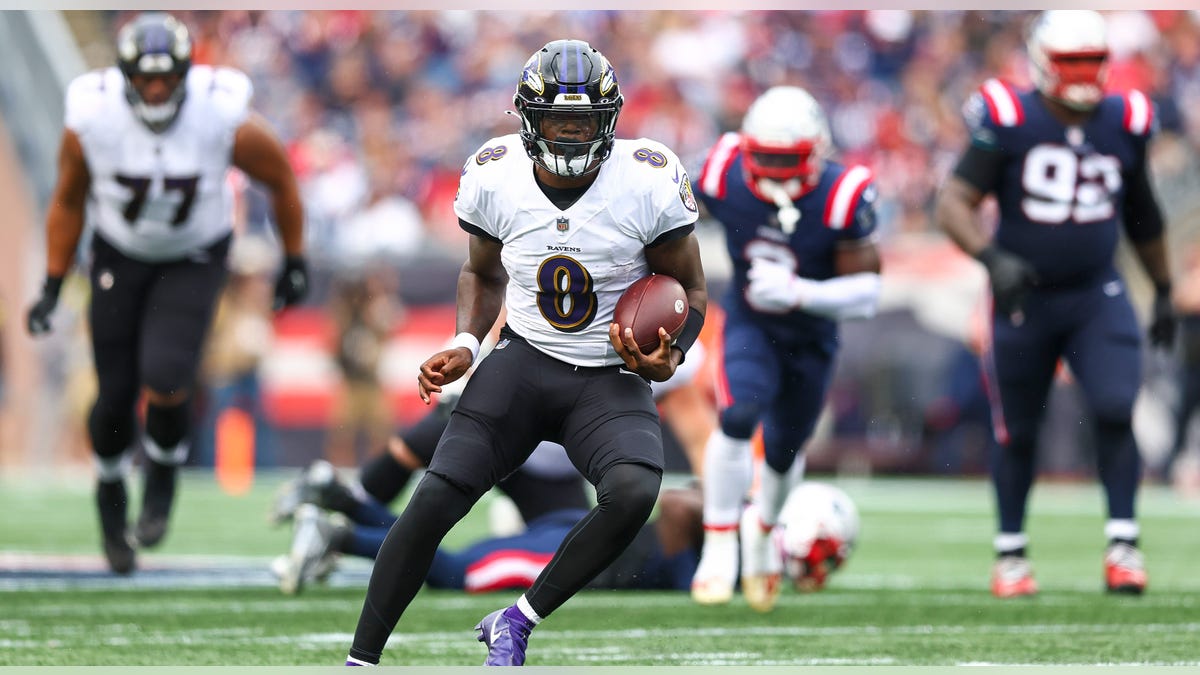 Lamar Jackson runs with ball