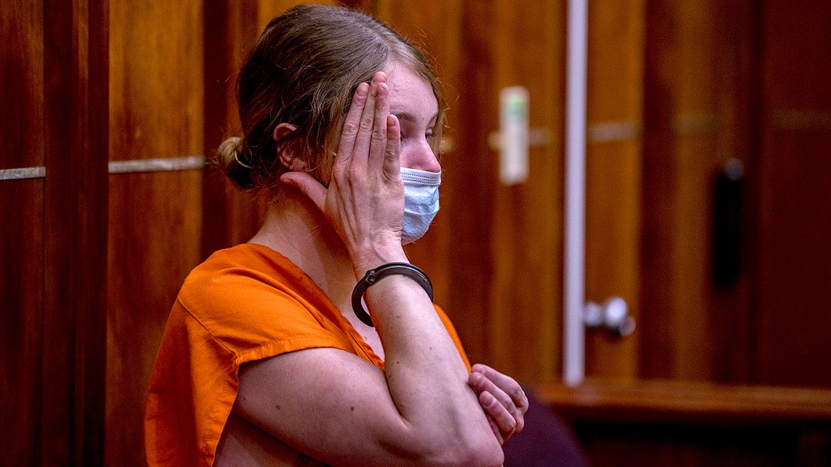 Courtney Clenney wearing an orange jail-issue jumpsuit at a court hearing