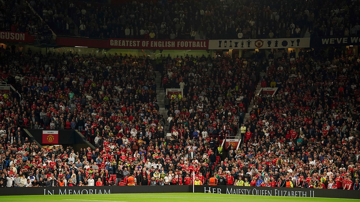 Manchester United fans stand for a moment of silence following the death of Queen Elizabeth II.