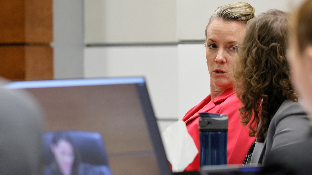 Nikolas Cruz's defense lawyer Melisa McNeill, wearing a pink blazer and talking to her associates at the defense table