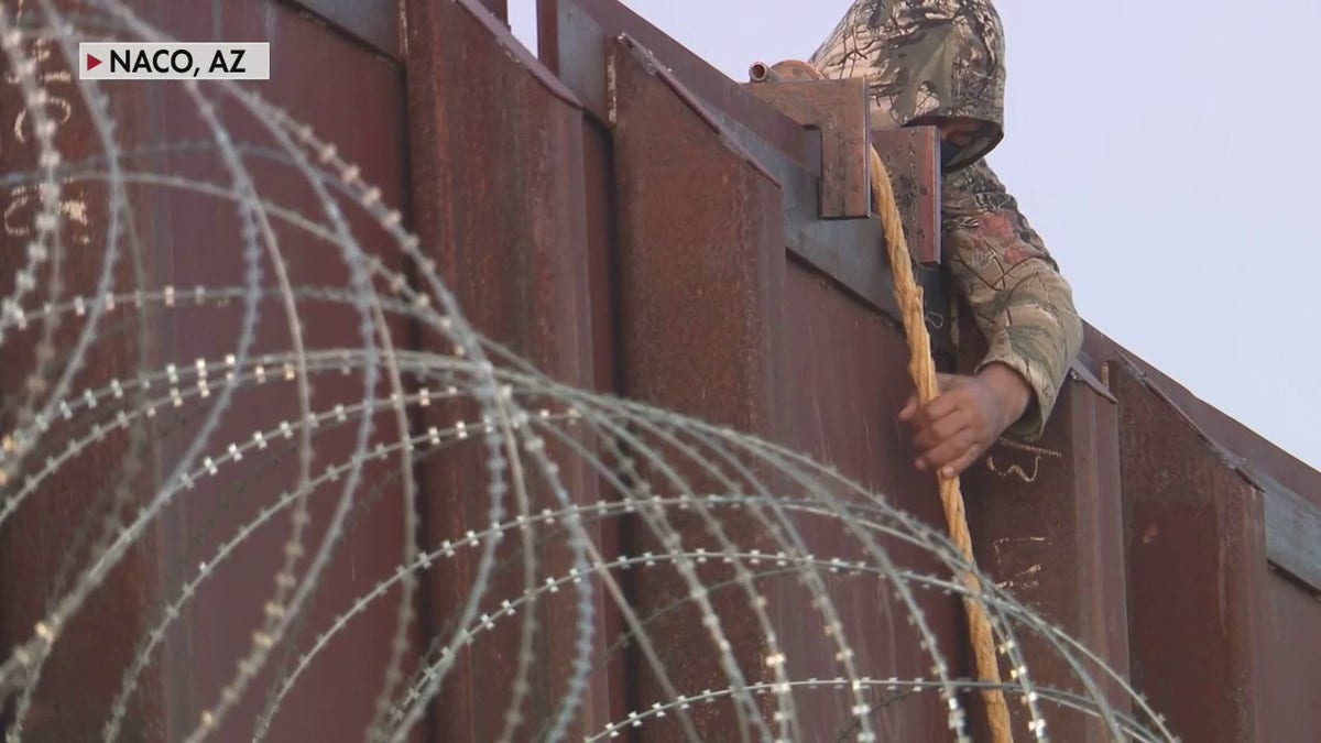 Human smuggler lowers migrant from Arizona border wall