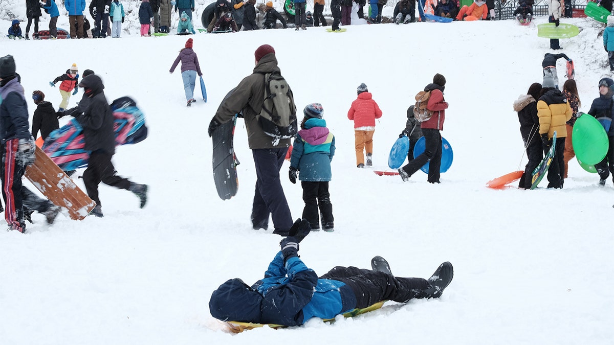 People sled during snowstorm in Brooklyn, New York City