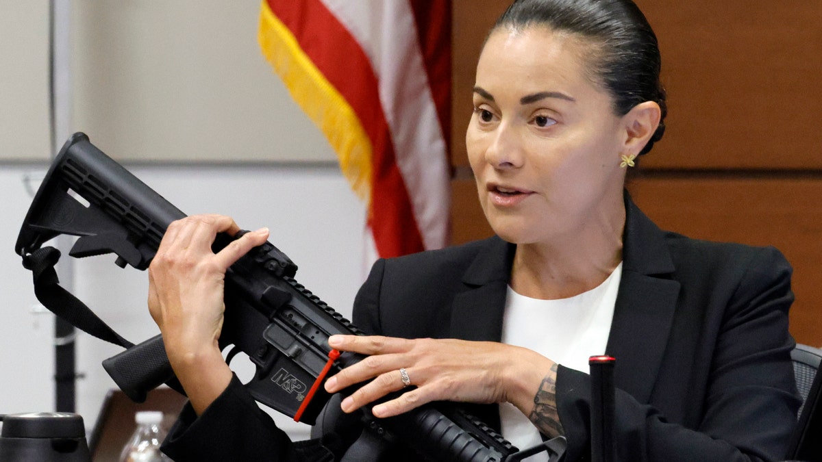 Sgt. Gloria Crespo holds up Nikolas Cruz's rifle