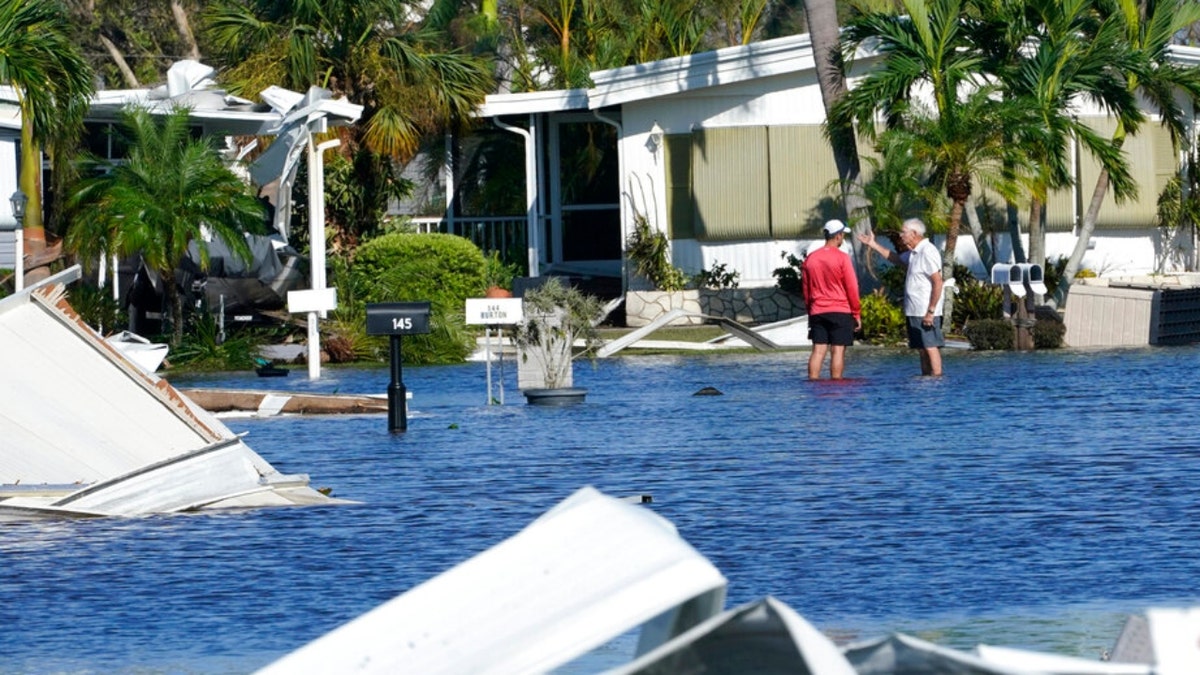 Hurricane Ian tailer park residents talk in a flooded area