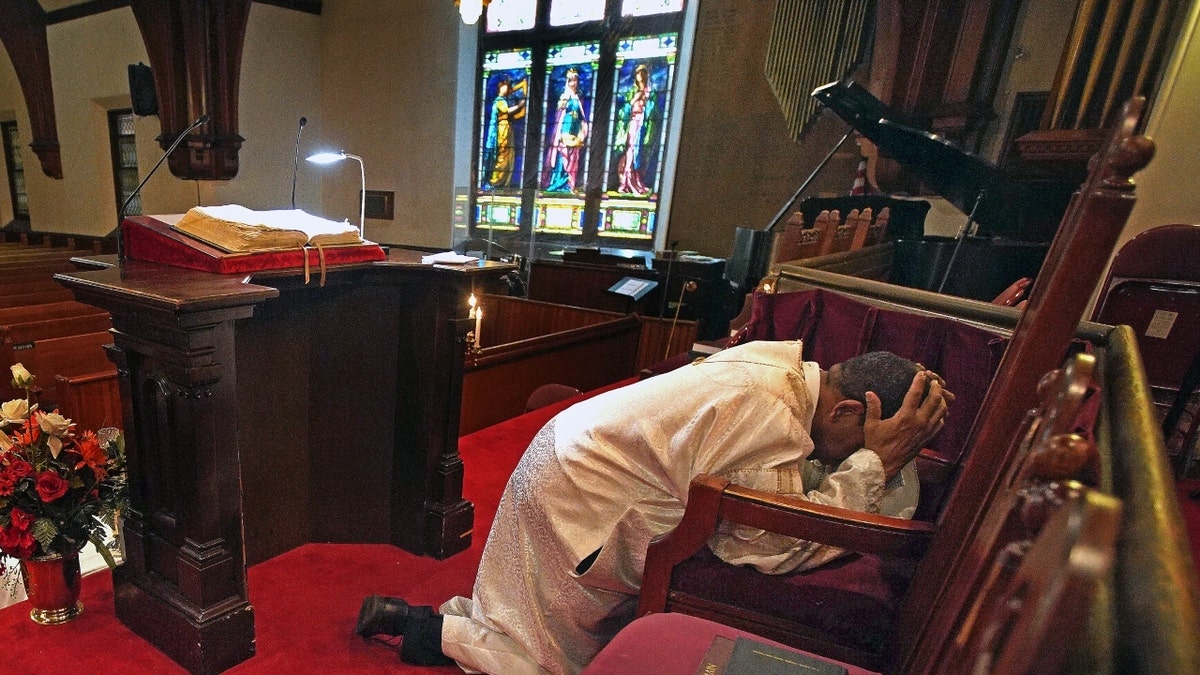 Rev. Dr. Gregory G. Groover, Sr., prays in Boston church
