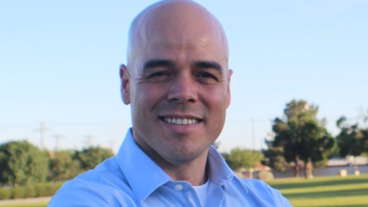 Robert Telles smiles for a government photo