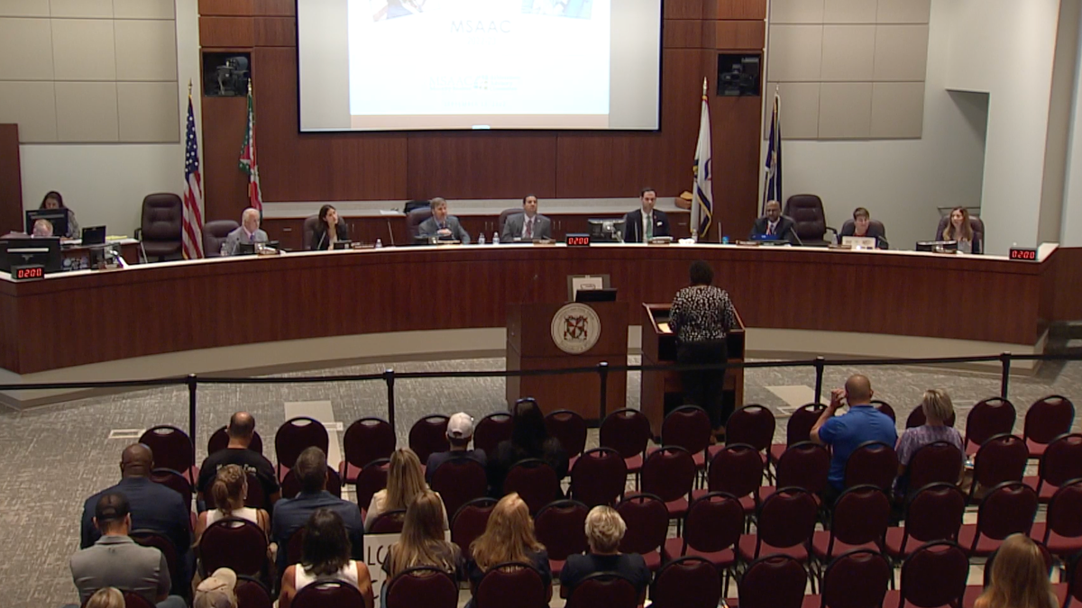 Members of the Loudoun County school board listen as virtual speakers address the board.