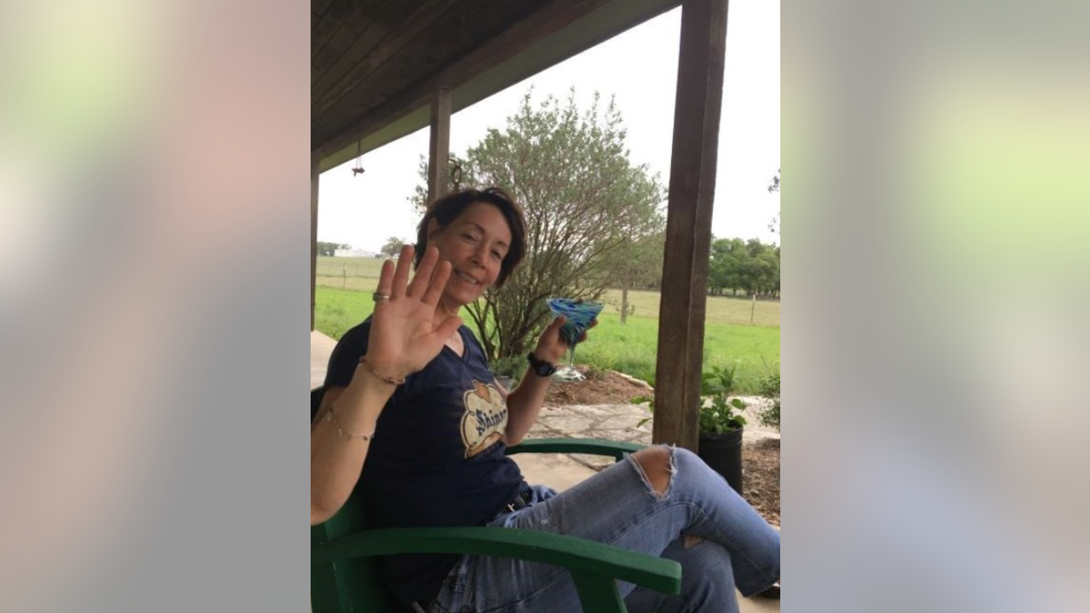 Dr. Melanie Kaspar sitting outside and sipping a cocktail