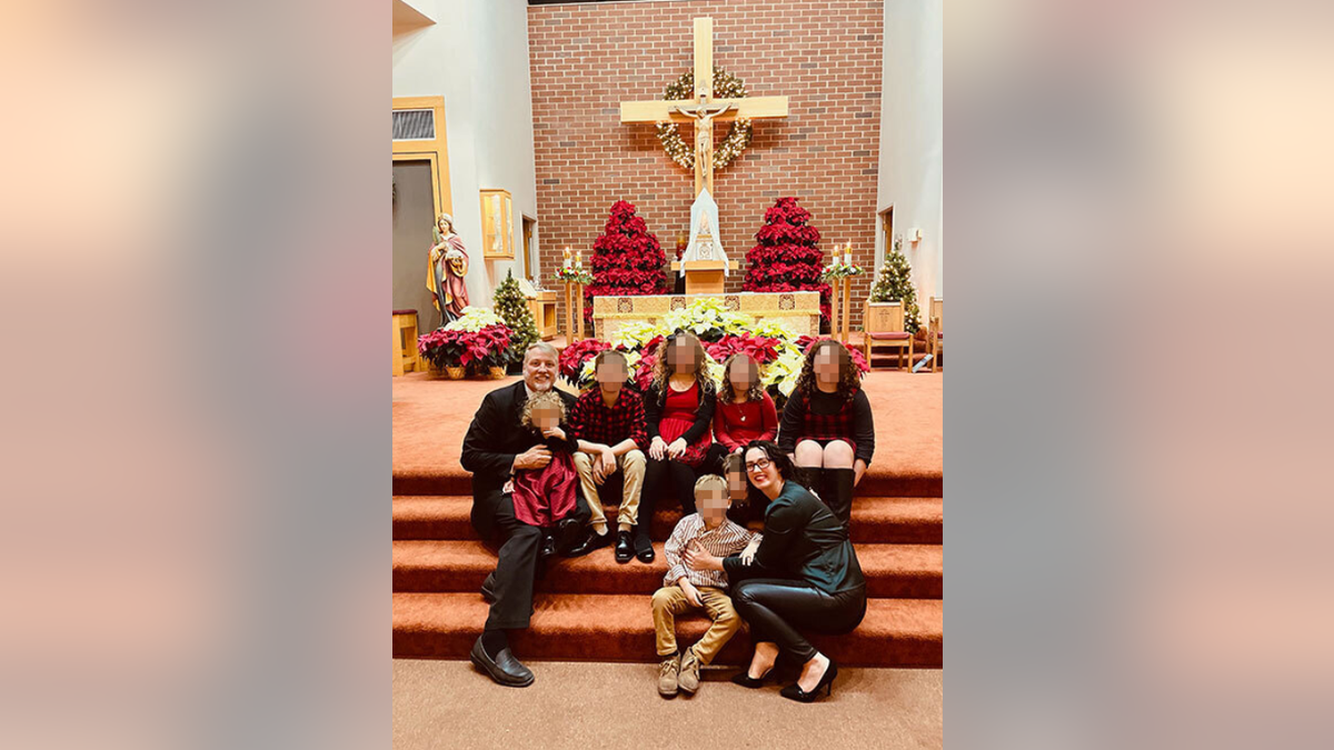 Mark Houck poses for photo with his family inside church