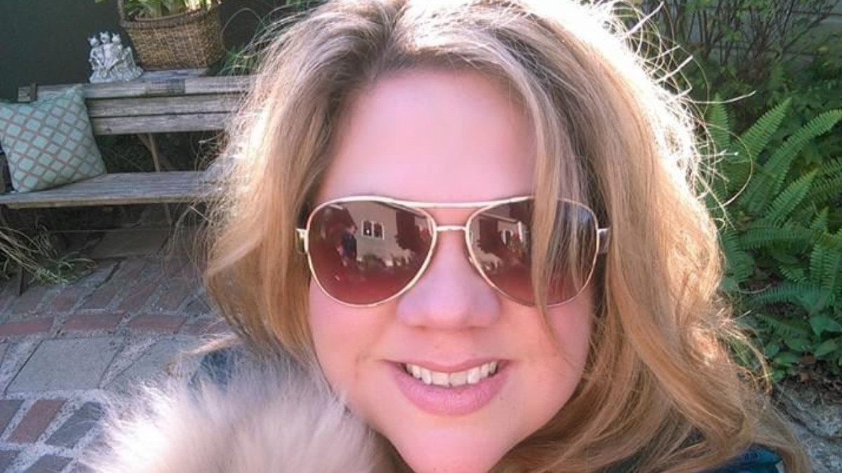 Michelle Reynolds wearing sunglasses and holding a dog