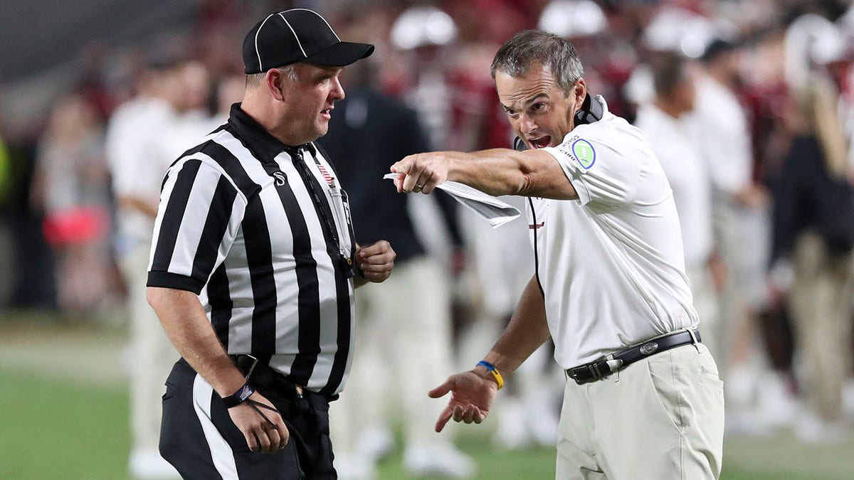 Coach Shane Beamer talks to game official