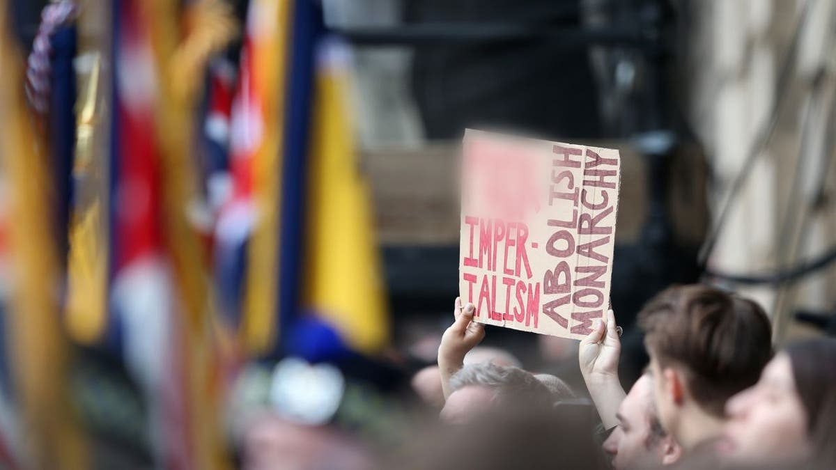 Anti-Royalists hold up a placard in protest