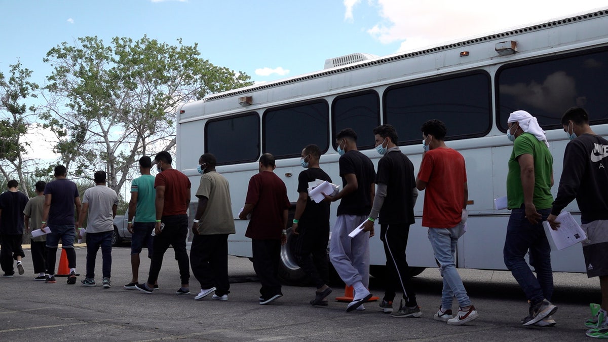 migrants walk off a border patrol bus in El Paso texas