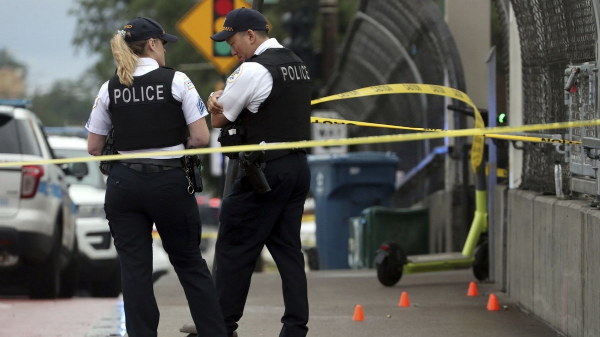 Chicago police officers standing behind yellow tape