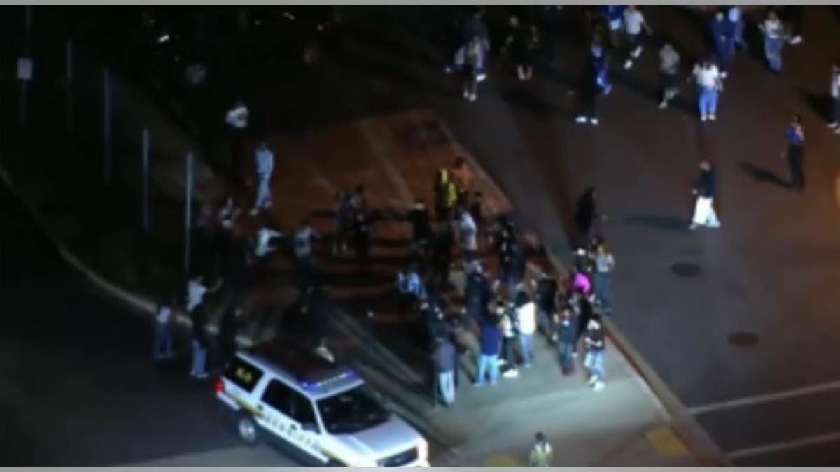 Large group of people and police in a parking lot