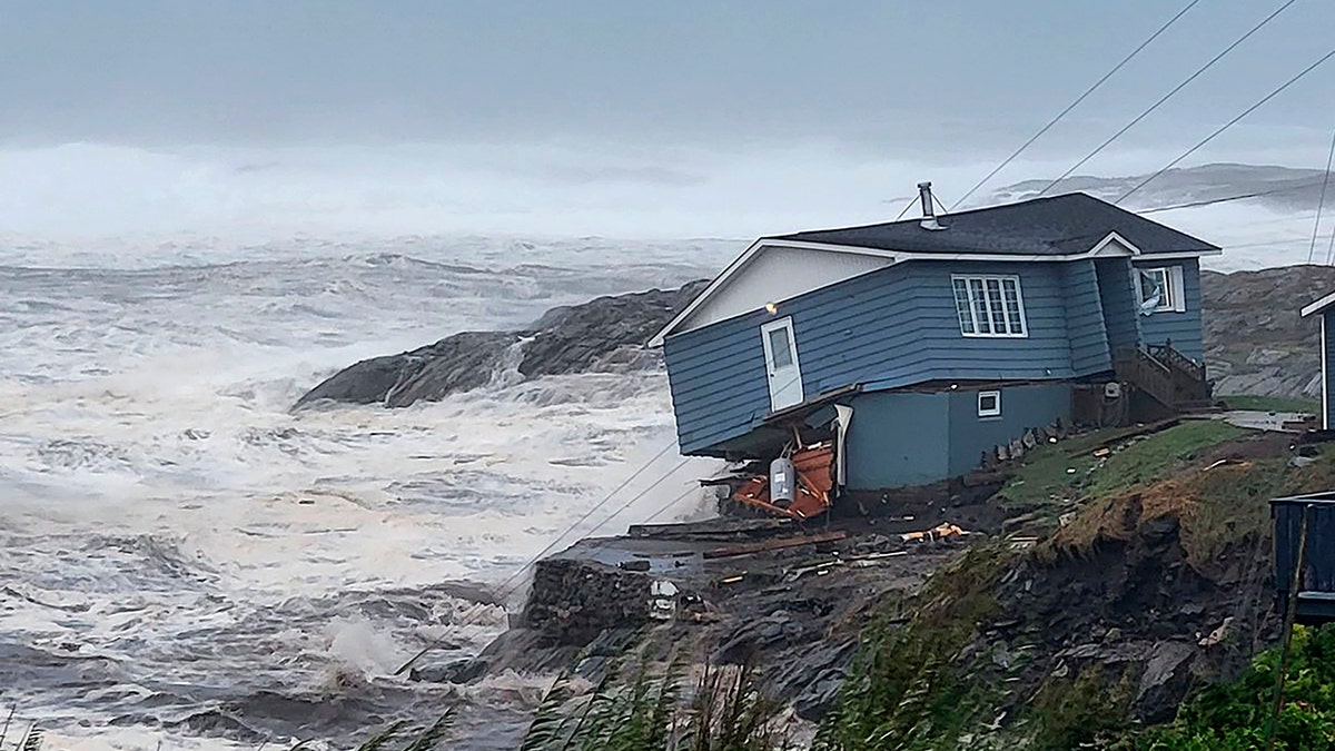 house on cliff falling into sea