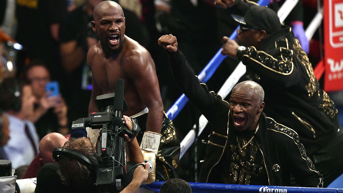 Floyd Mayweather Jr. (L) and Floyd Mayweather Sr. celebrating