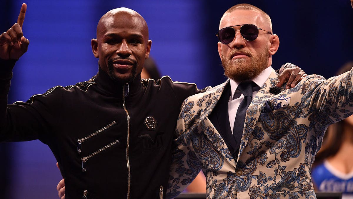Floyd Mayweather Jr. and Conor McGregor pose for pictures during conference