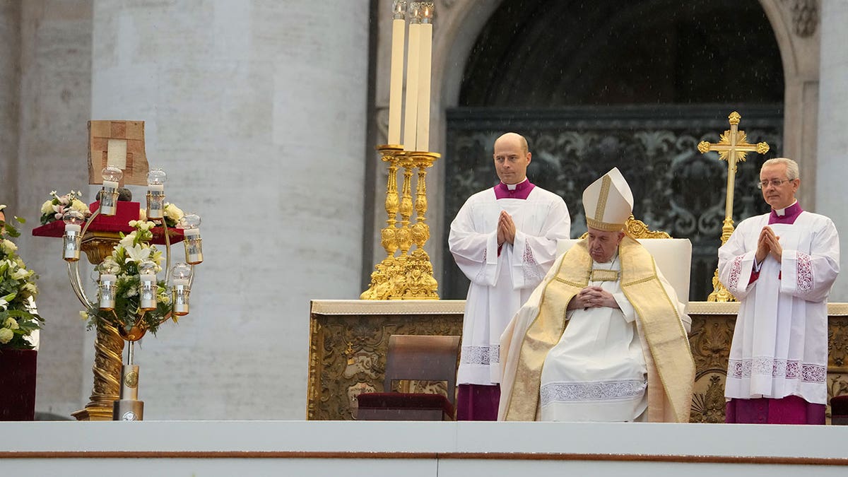Pope Francis sits in a chair during an outside ceremony beatifying Pope John Paul I