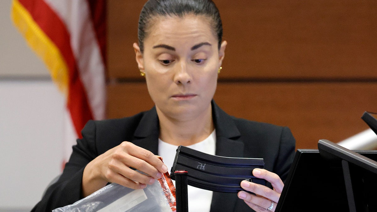 Sg.t Gloria Crespo holds up a magazine with a swastika etched on both sides