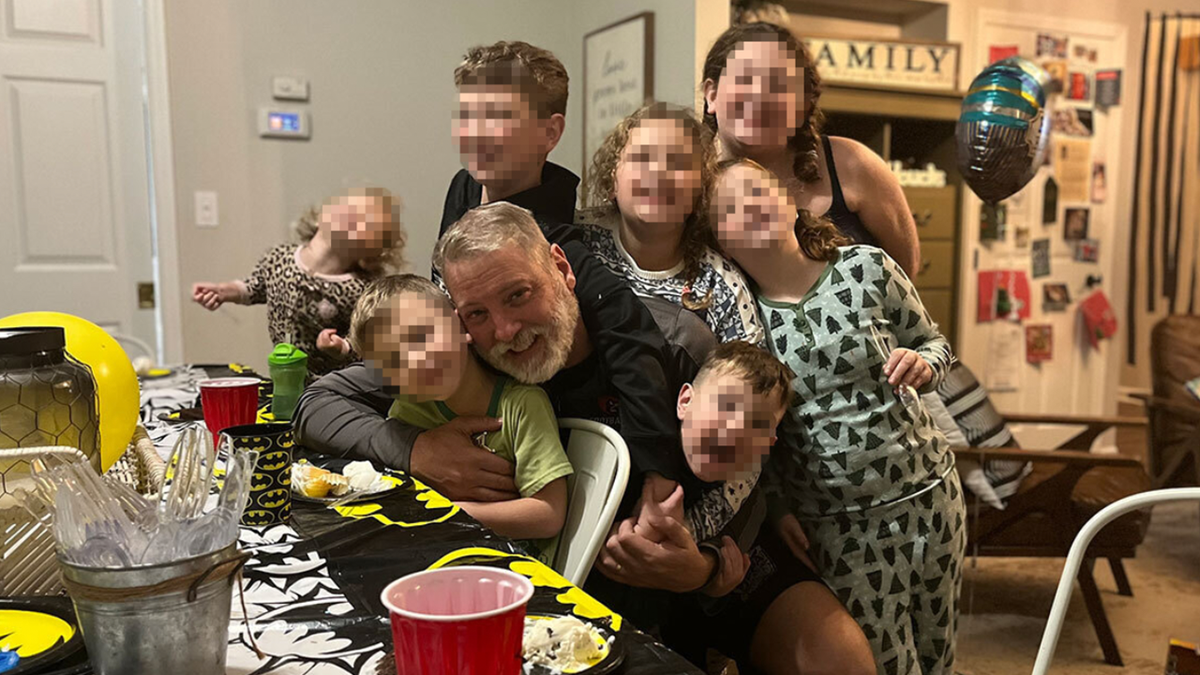 Mark Houck seen smiling while surrounded by his children
