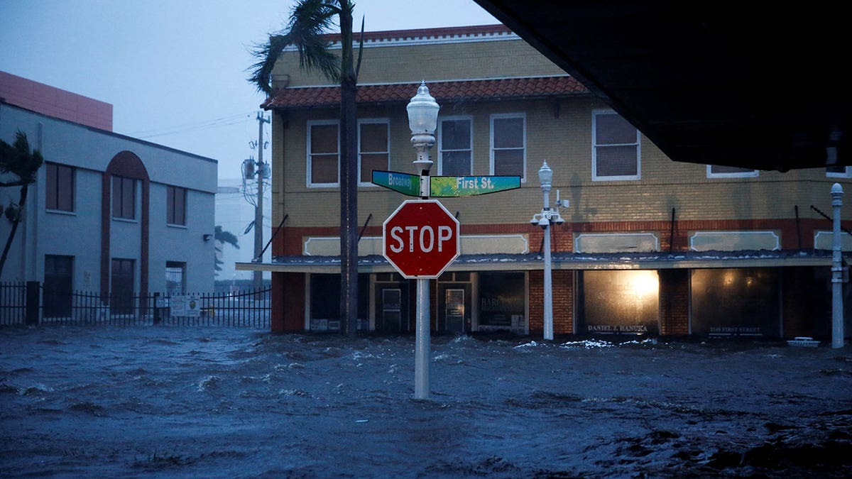 A Stop sign stands in a flooded Florida street during a gloomy afternoon as Hurricane Ian hits the state