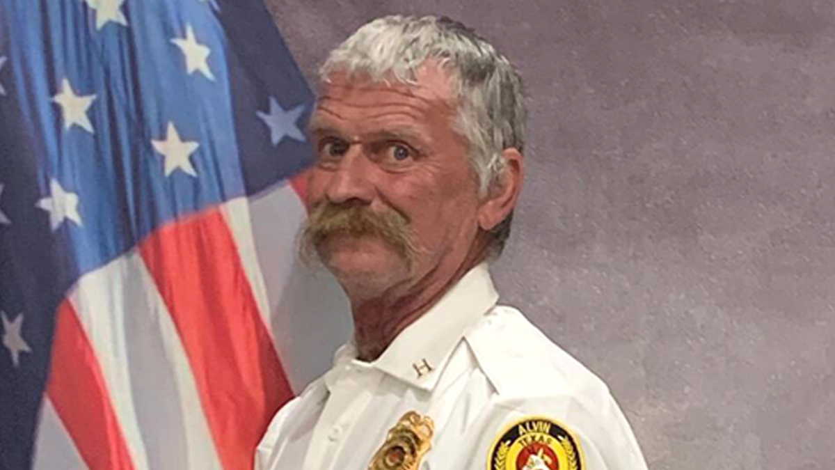 Firefighter posing for a picture with American flag in background