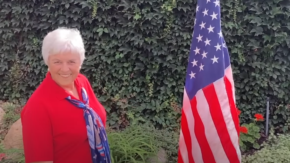 Linda Paulson rapping next to an American flag