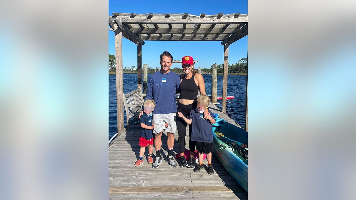 Eliza Fletcher smiling on a dock with her husband and children