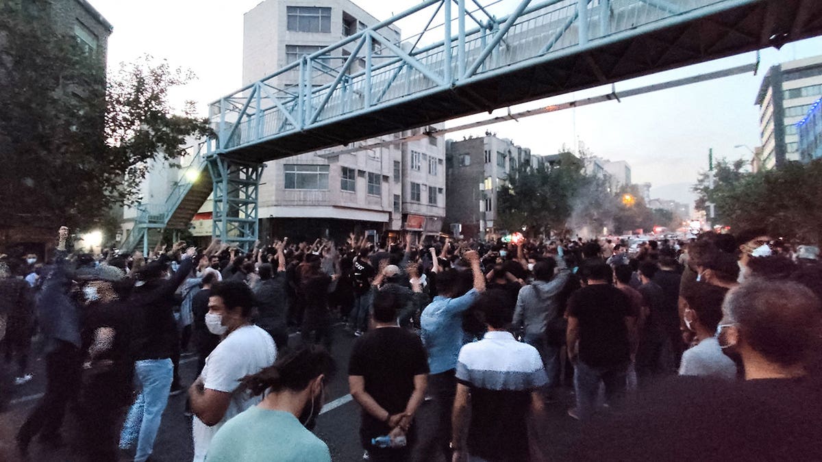 Protesters gather under a bridge in Tehran as they protest during daytime