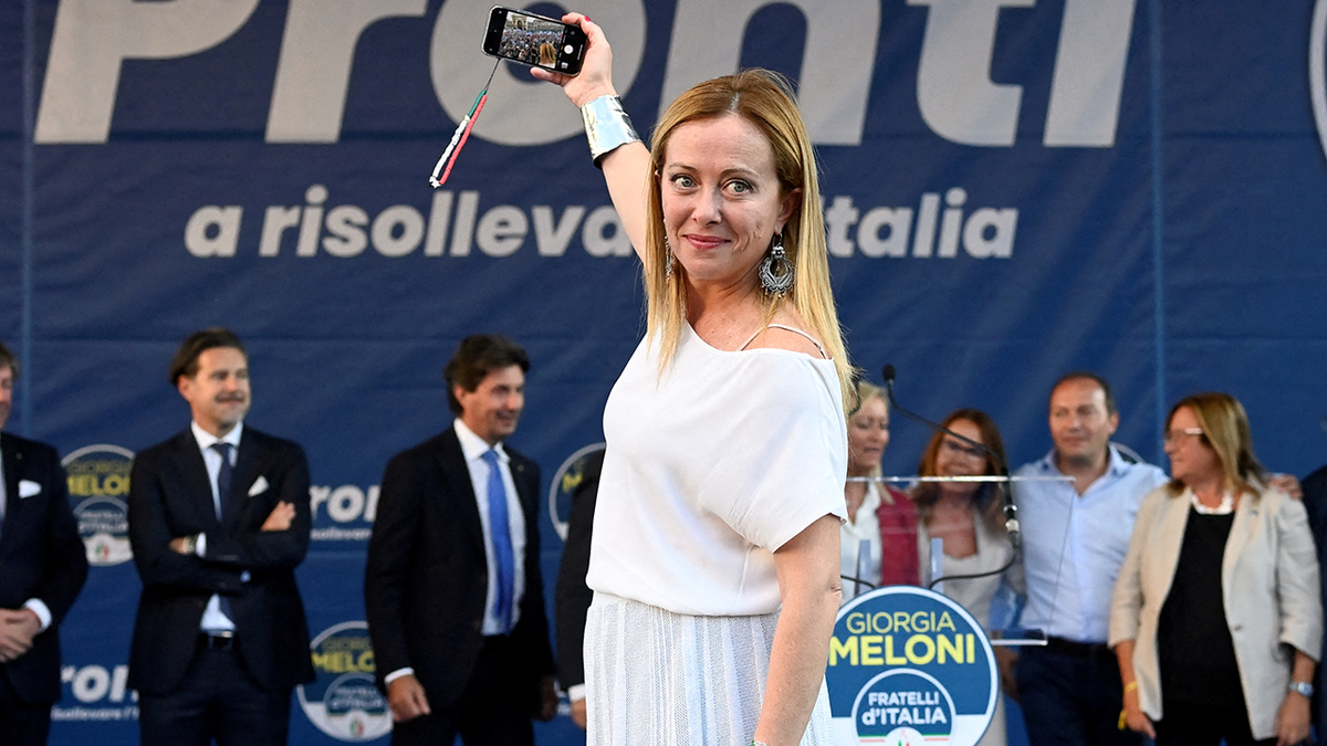 Giorgia Meloni takes a selfie in Milan earlier in September on a stage