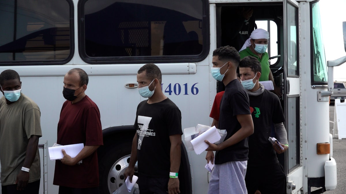 Migrants walk off Border Patrol bus in El Paso, Texas