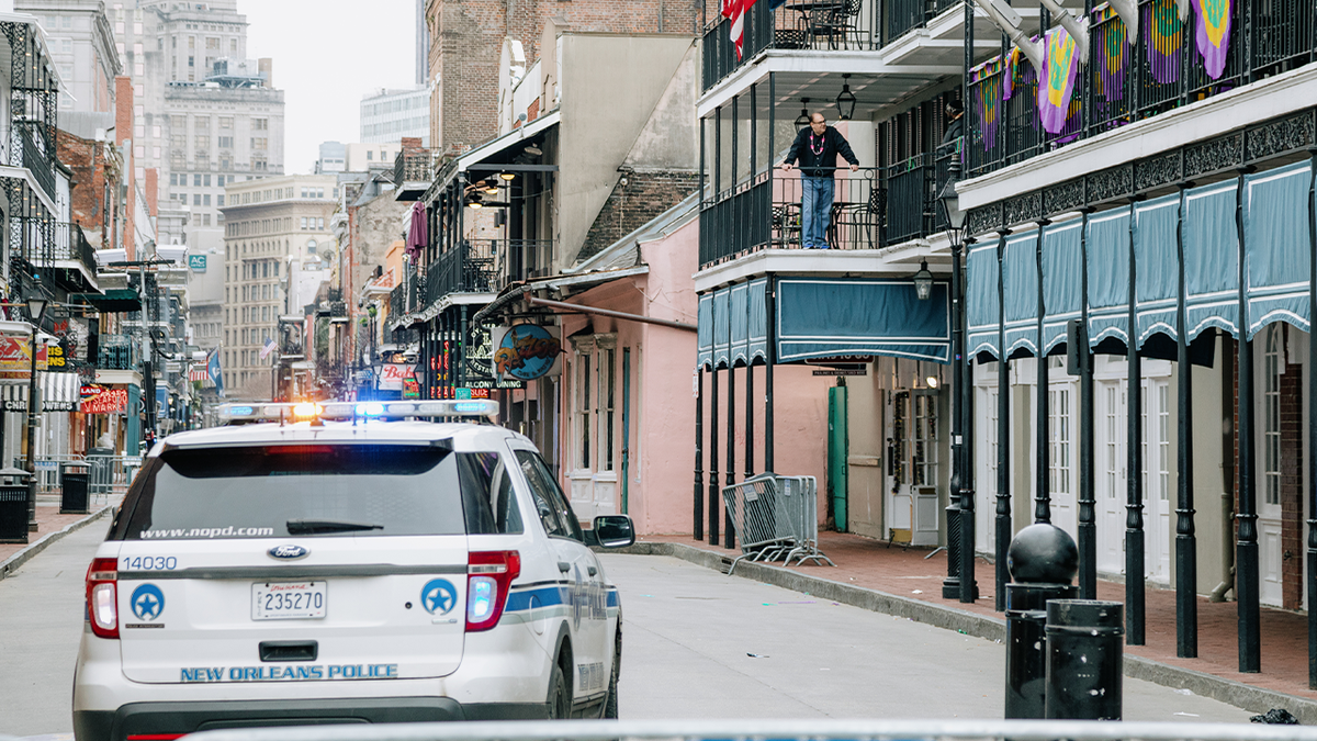 Photo shows New Orleans Police car on Bourbon Street during Mardi Gras.