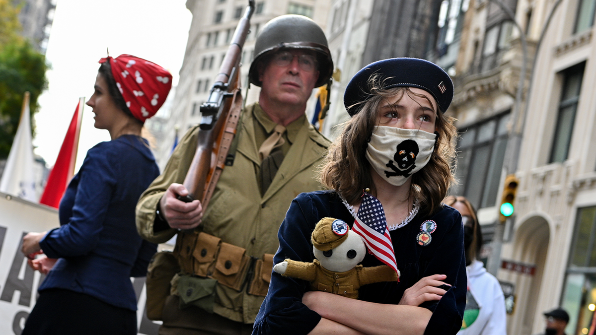 Photo shows girl dressed as a child during Revolutionary War participating in reenactment in NYC