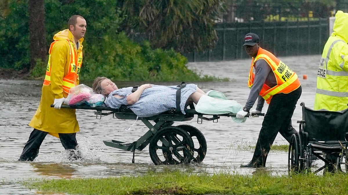 EMS workers carry a patient on a stretcher out of an Orlando nursing home during Hurricane Ian
