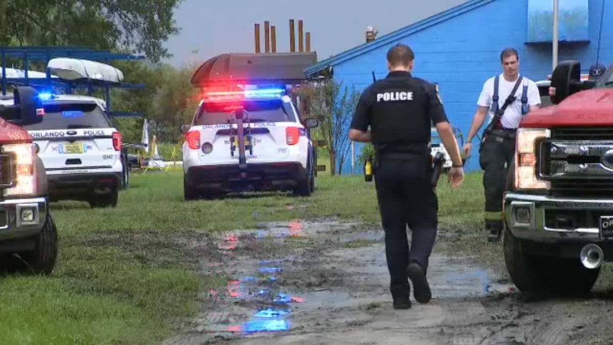 Police officer walking toward firefighter at the scene of missing rower in Orlando, Fla.