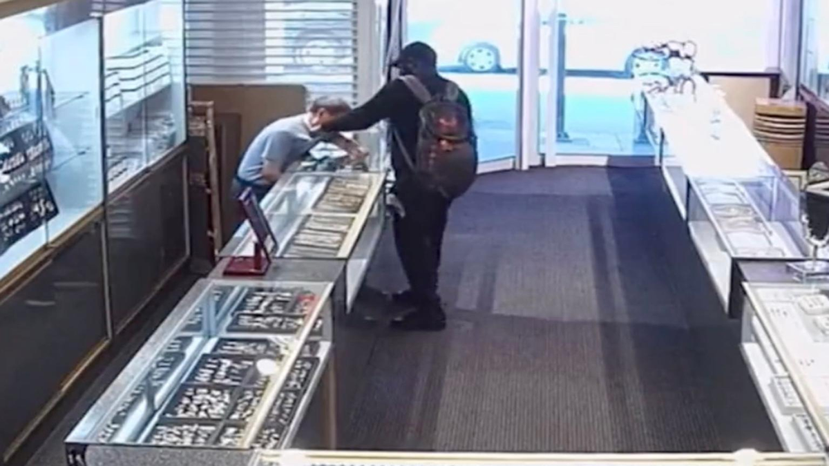 Attacker grabs Wilmington store owner's throat.