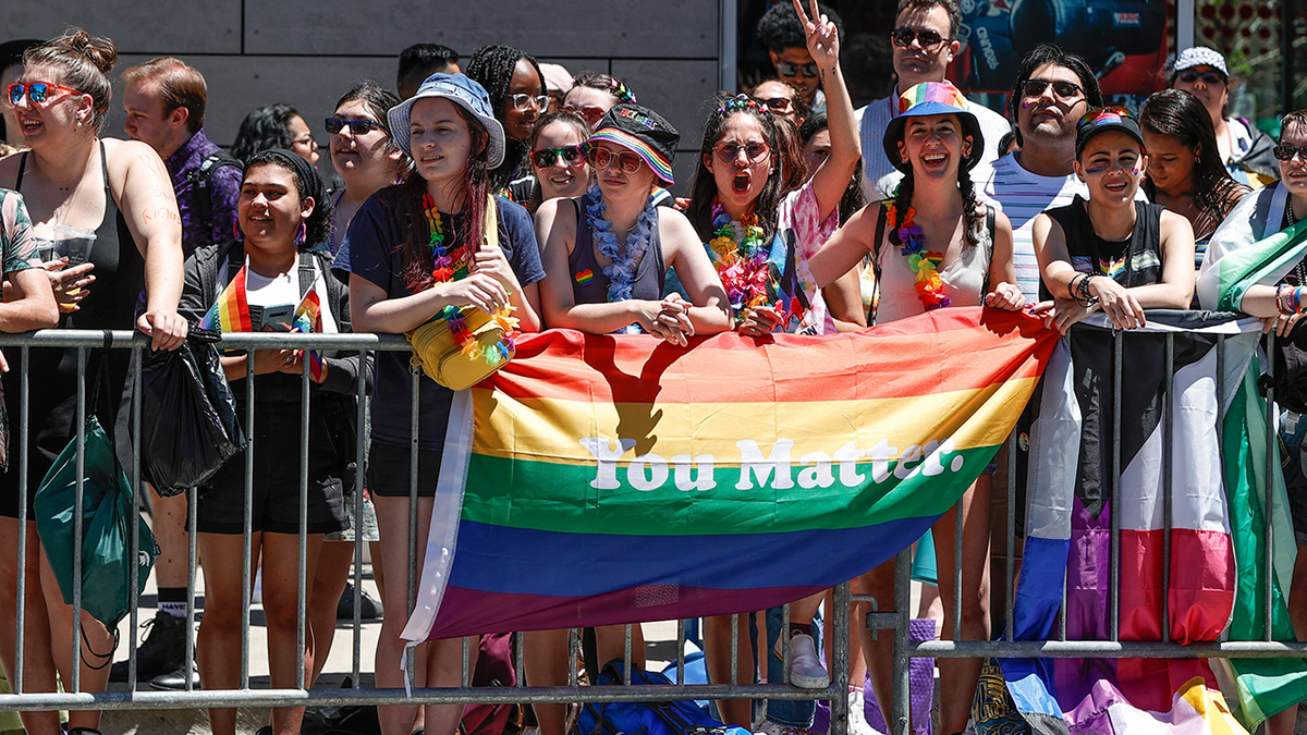 Photo shows people in Chicago with big pride flag reading "you matter"