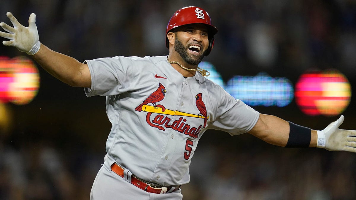 Albert Pujols watching after hitting a home run during a baseball game.
