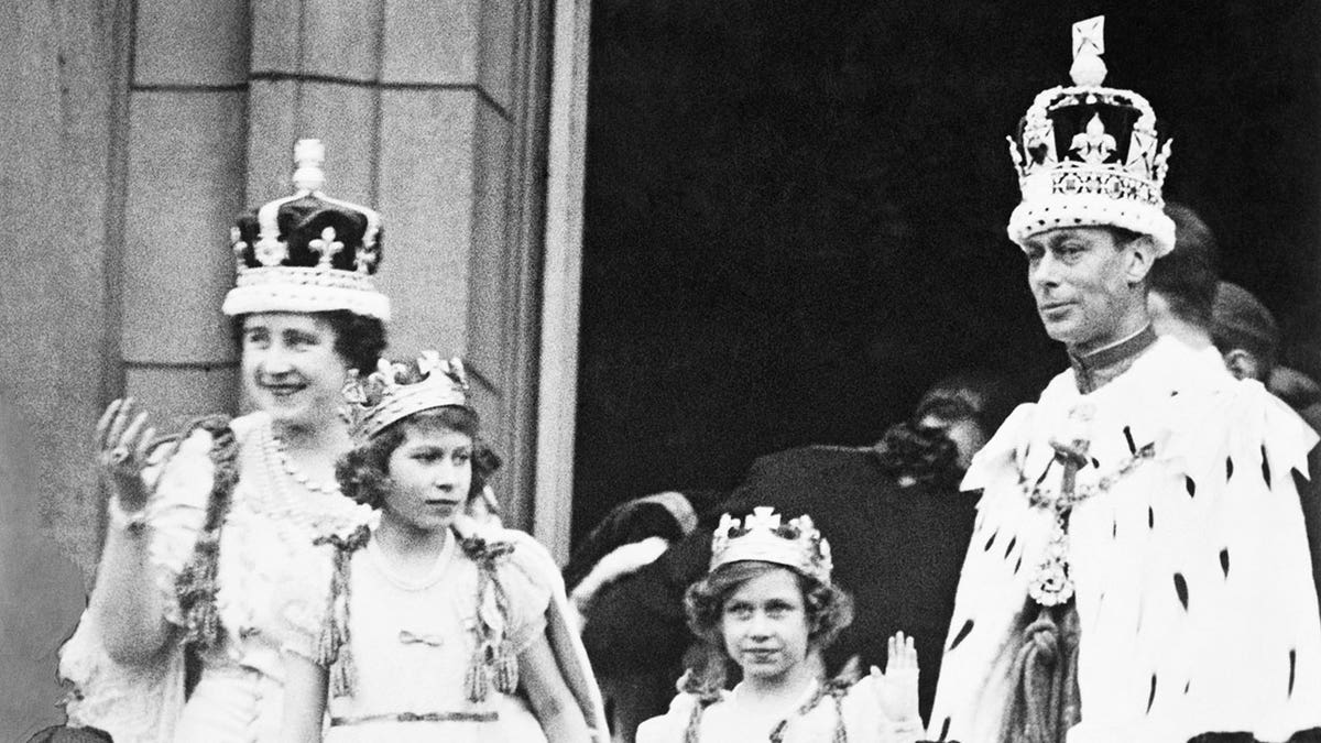 A black and white photo of Queen Elizabeth, sister Margaret, and mother and father on the balcony of Buckingham Palace
