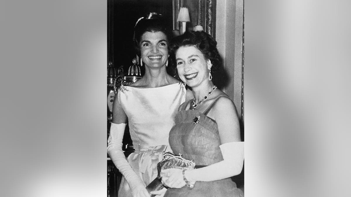 A black and white photo of Queen Elizabeth and Jackie Kennedy during a dinner